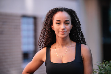 photo of a black girl with long hair posing and wearing sports clothes. Fitness