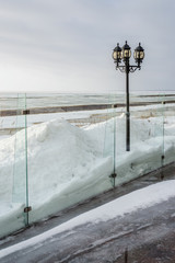 glass fence with snow drifts and a lantern