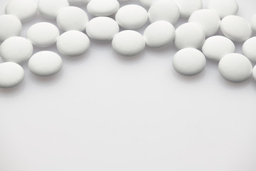 Group of white pills on white background - healthcare and medicament concept. Pharmaceutical industry. Pharmacy.