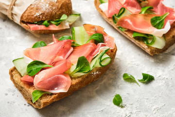 Italian sandwiches with bacon, cucumber and fresh herbs. Ciabatta with meat