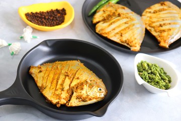 Fresh Marinated Pomfret fish or butter fish is cleaned and ready for frying along with spices. ingredients and recipe background with copy space
