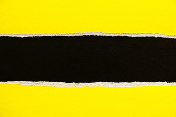 Black and yellow torn and ripped sheet of cardboard paper texture background. Can be used for text.