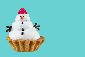 Snowman Cupcake. Christmas cake on a blue background.