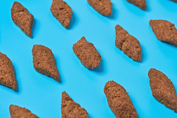 Rows of brown spicy pieces of rusk bread lies on blue desk in sport bar or pub. Close-up