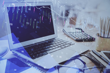 Financial chart drawing and table with computer on background. Double exposure. Concept of international markets.