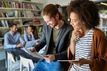 Fototapeta premium Happy young business people colleagues talking working in office