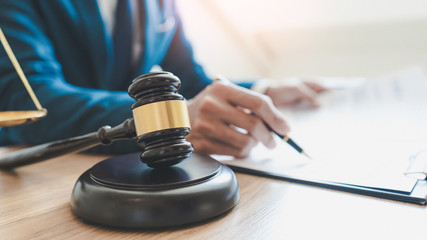 lawyer judge reading documents at desk in courtroom.