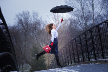 A girl in a hat walks in the rain. Mery Poppins goodbye!
