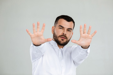 Fototapeta premium handsome bearded man showing stop gesture on gray background.