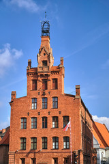 A historic building with a red brick tower in Poznan.