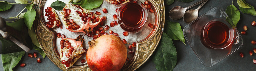 Pomegranate tea on dark background, flat lay