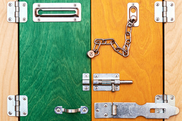 Colored wooden toy barn doors with many metal locks, bolts and a heck. Entrance is open