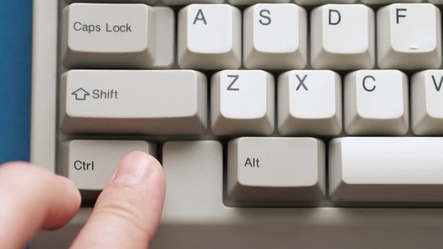 Male finger pushes CTRL + SHIFT button on white keyboard. Slow motion and macro view