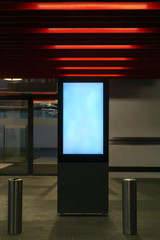 Blank mock up light box stands in front of the store entrance