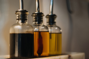 Glass bottles of oil on a kitchen table