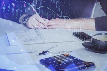 Double exposure of man doing analysis of stock market with forex graph.