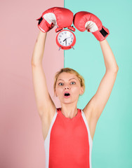 Establishing the clock time. time to fight. time for success. win the day. surprised woman boxing...