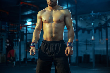 Fototapeta na wymiar Caucasian man practicing in weightlifting in gym. Caucasian male sportive model posing before training, looks confident and strong. Body building, healthy lifestyle, movement, activity, action concept
