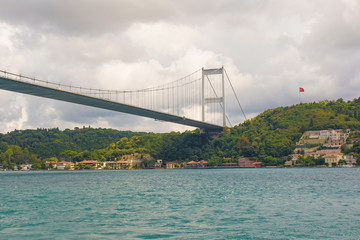 Fototapeta na wymiar The Fatih Sultan Mehmet Koprusu Bridge in Istanbul, Turkey. This suspension bridge connects Hisarustu in Europe with Kavacik in Asian. Taken from Rumeli Hisari.