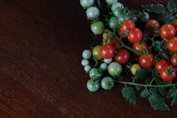 Fresh tomatoes on wet wooden table background