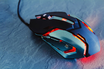 Red gaming mouse on stone texture table