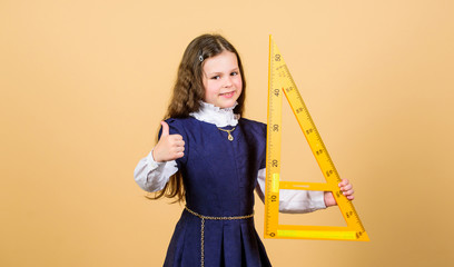 I love mathematics. Smart and clever concept. Pupil cute girl with big ruler. School student study geometry. Sizing and measuring. Kid school uniform hold ruler. Education and school concept