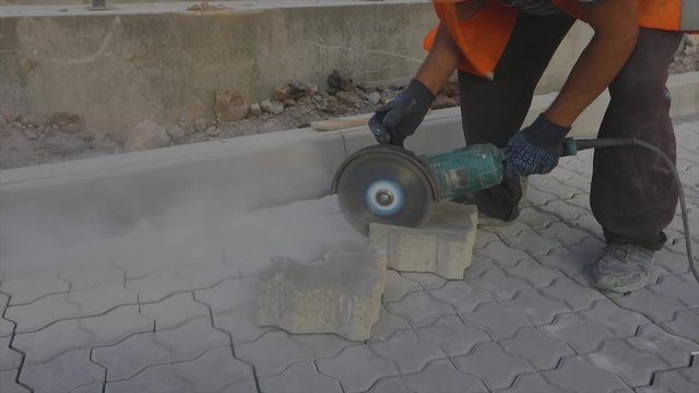 Cut a brick with a circular saw close-up. Grinder sawing tile