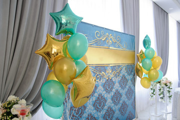 lateral view of a photo wall with golden and blue baloons at a boy's birthday party in a restaurant
