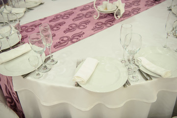 top view of a white arranged table with lila details in a wedding banquet hall