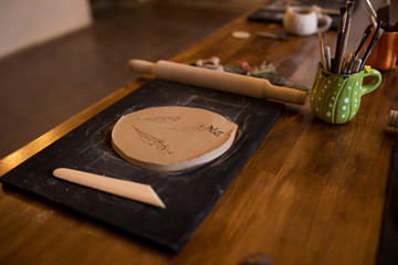 A master class in modeling a clay jug. Table with clay and a tool for creativity.