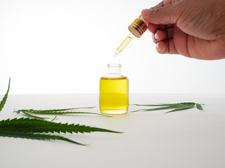 Hand with pipettes and cannabis extract oil.