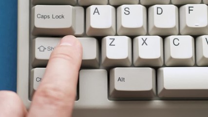 Male finger pushes SHIFT button on white keyboard. Slow motion and macro view