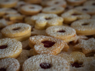 Homemade Linzer Christmas cookies. Biscuits with shortcrust pastry and strawberry jam on dark background.