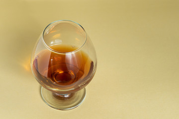 Cognac in a glass on a warm background