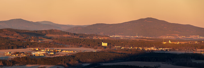 hilly landscape at sunrise, in foreground rural landscape with forests, meadows, fields and villages, in background forested hills and mountain (Klet (Schöninger), South Bohemia, Czech republic