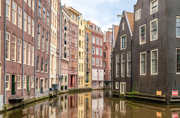 Obraz premium Row of typical colourful dutch houses reflected in water on Amsterdam canal. Amsterdam, Netherlands.