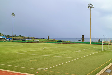 Soccer Field at Hanga Roa Town with Moai Statue and Pacific Ocean in the Backdrop, Easter Island, Chile