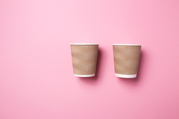 Paper cup for hot coffee or tea on a pink isolated background.