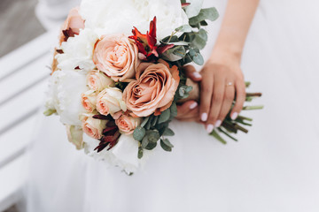Fresh wedding bouquet of roses in tender brides hands. Wedding, beauty , floral concept