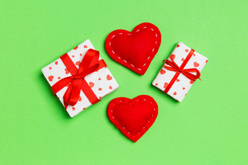 Top view of colorful valentine background made of gift boxes and red textile hearts. Valentine's Day concept