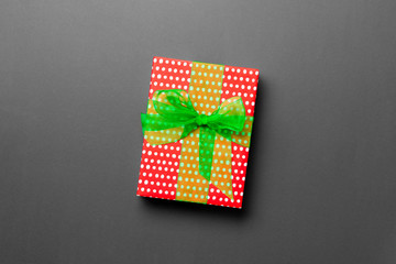wrapped Christmas or other holiday handmade present in paper with green ribbon on black background....