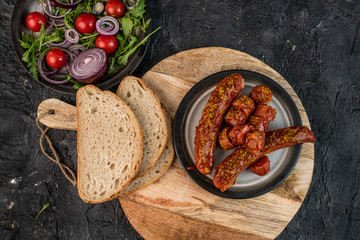 German, traditional baked sausage with curry sauce on a dark background