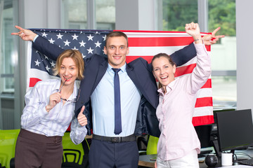 Business people, one man and two women, together with the USA flag. Teamwork.