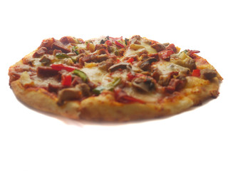 Pizza in round shape, topped with meat, ham, mushroom and veggies