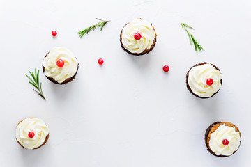 Cupcakes with cream cheese, cranberries and sprigs of rosemary. Horizontal orientation, copy space.
