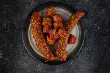 German, traditional baked sausage with curry sauce on a dark background