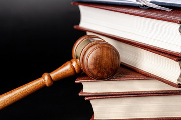 Wooden gavel and juridical books close up