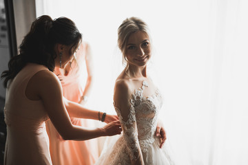 Hands of bridesmaids on bridal dress. Happy marriage and bride at wedding day concept