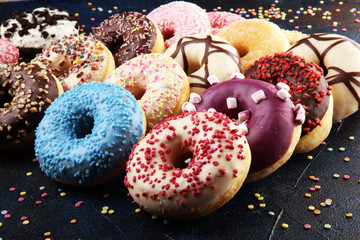 assorted donuts with chocolate frosted, pink glazed and sprinkles donuts