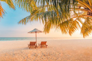 Beautiful tropical sunset scenery, two sun beds, loungers, umbrella under palm tree. White sand,...
